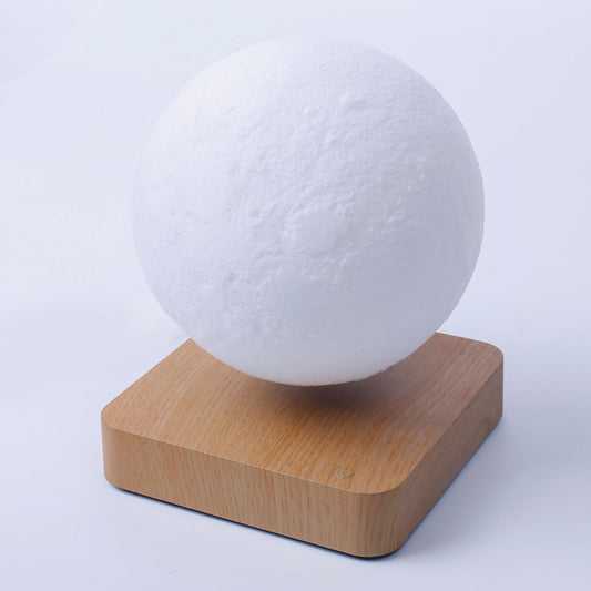 White spherical object on a wooden base against a light gray background